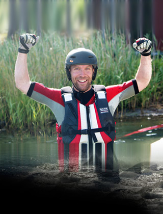Glad_flyboardkille_i vattnet Glad flyboardkille som står med vatten till midjan